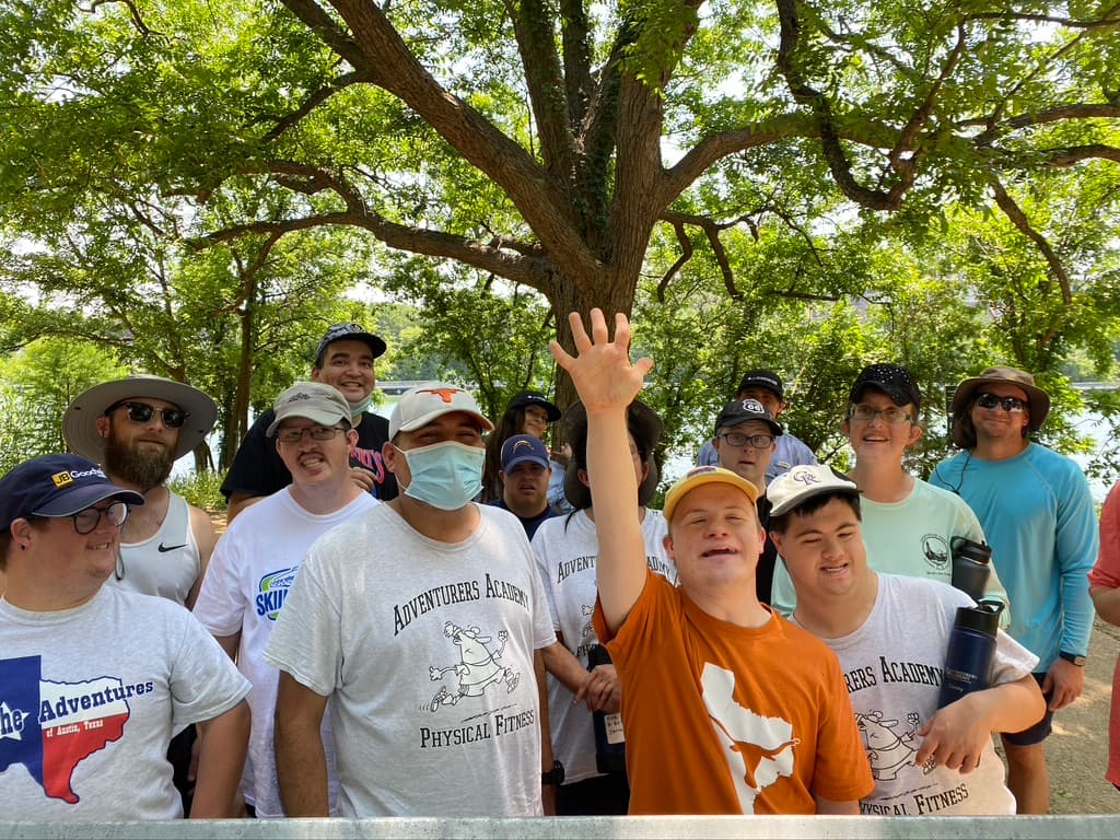 A youth outdoor-education group celebrating at a summit